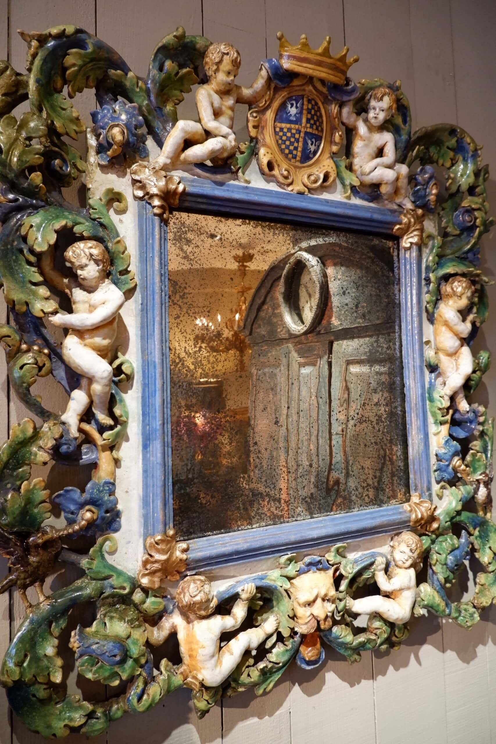 Grand miroir orné de Putti et d’une couronne sur blason- en faïence vernissée polychrome – Italie XIXe